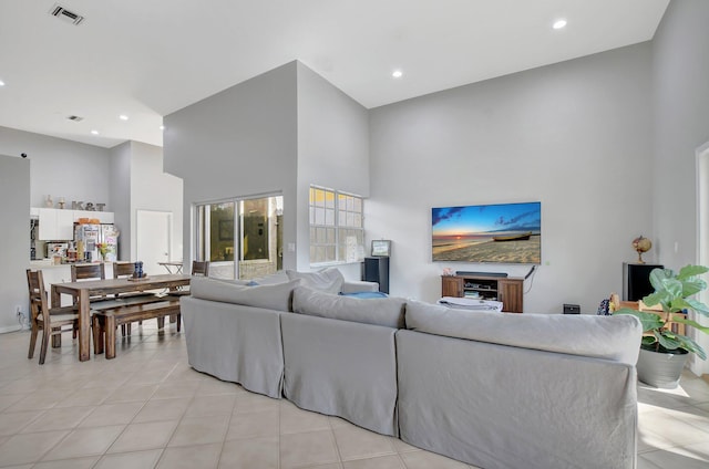 living room featuring a towering ceiling and light tile patterned flooring