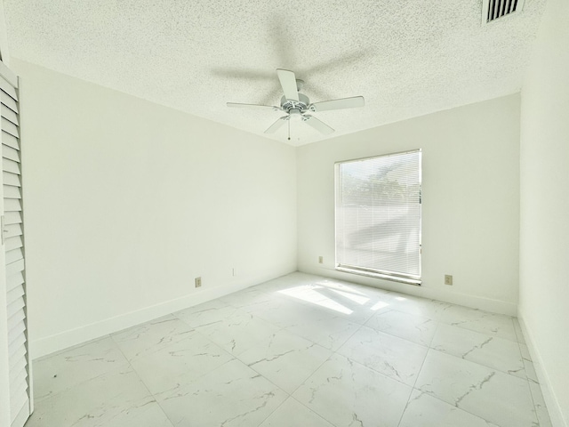 spare room with ceiling fan and a textured ceiling