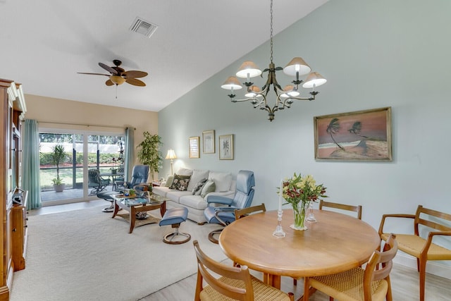 dining area featuring ceiling fan with notable chandelier, high vaulted ceiling, and light wood-type flooring