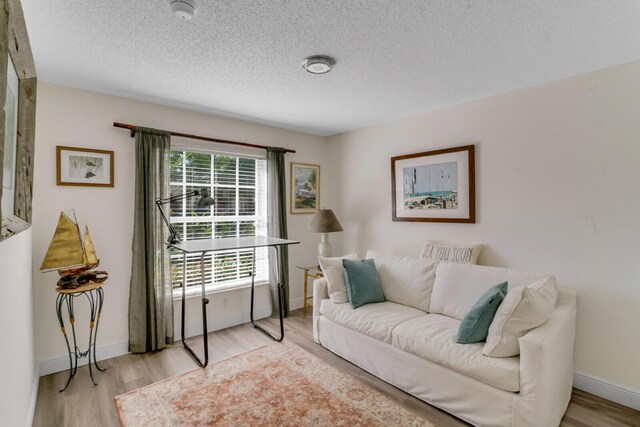 living room with light wood-type flooring, ceiling fan, baseboards, and vaulted ceiling