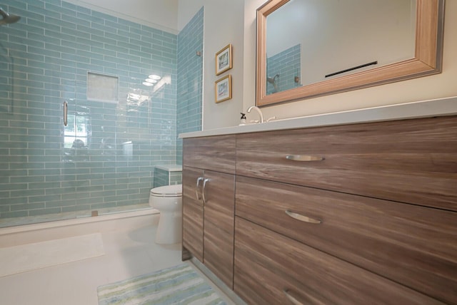 bathroom featuring a stall shower, vanity, toilet, and tile patterned floors