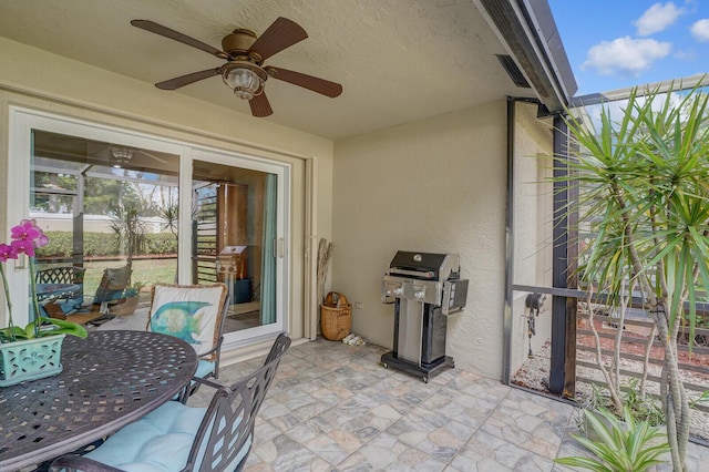 view of patio featuring a lanai, a grill, and a ceiling fan