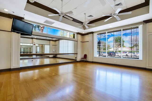 gym with crown molding, ceiling fan, and a high ceiling