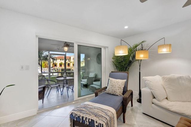 living area with ceiling fan and tile patterned flooring