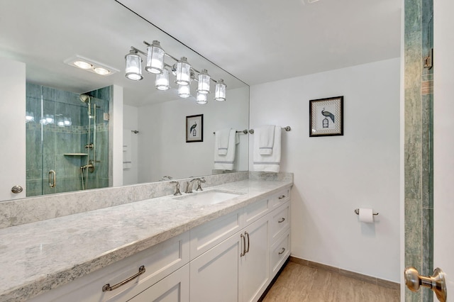 bathroom with a shower with door, vanity, and hardwood / wood-style floors