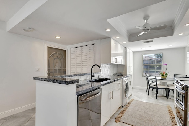 kitchen with appliances with stainless steel finishes, sink, white cabinets, ceiling fan, and a raised ceiling