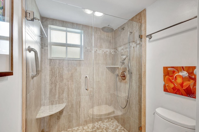 bathroom with a shower with shower door and toilet