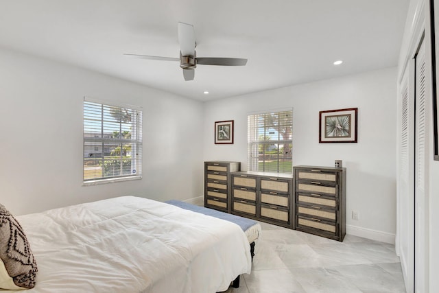 bedroom featuring multiple windows, ceiling fan, and a closet