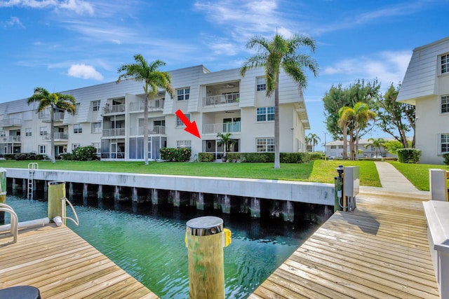 dock area with a lawn and a water view