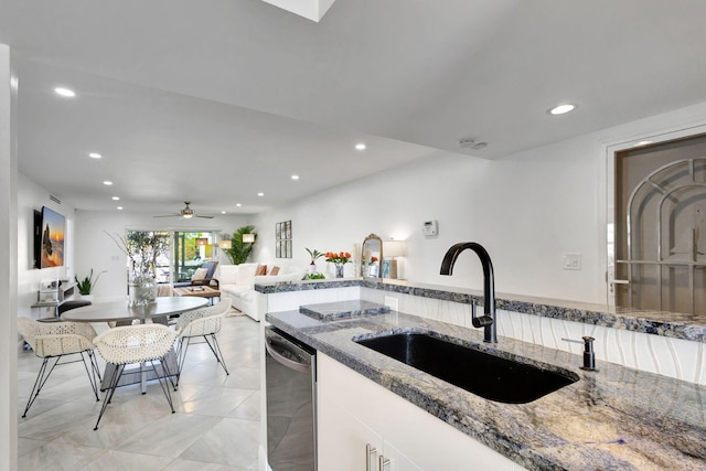 kitchen with white cabinetry, dark stone counters, dishwasher, and sink