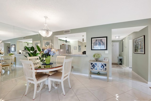dining space featuring light tile patterned floors, baseboards, and visible vents