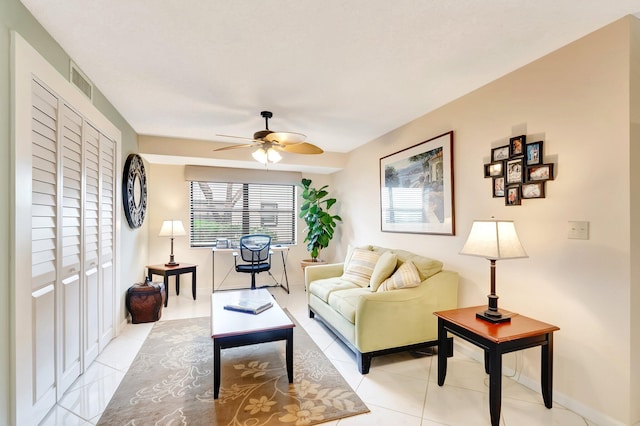 living area featuring visible vents, baseboards, ceiling fan, and light tile patterned floors