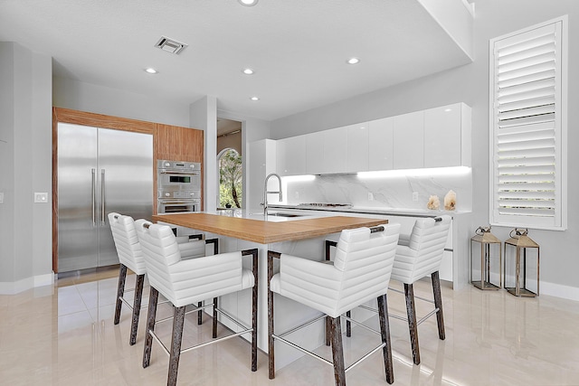 tiled dining space featuring a healthy amount of sunlight and sink