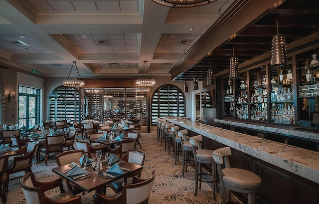 interior space with crown molding, bar area, coffered ceiling, and beamed ceiling