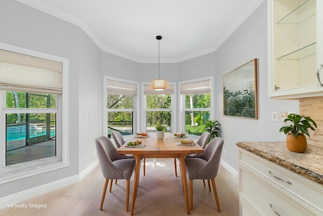 dining space with ornamental molding and light wood-type flooring