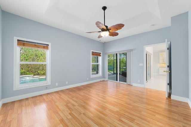 spare room with ceiling fan, a healthy amount of sunlight, and light hardwood / wood-style flooring