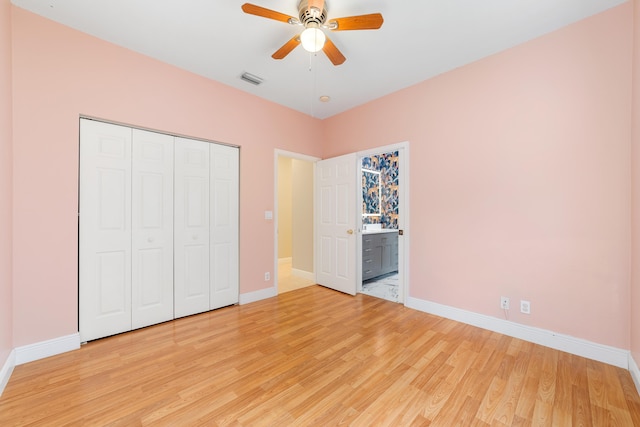 unfurnished bedroom featuring light hardwood / wood-style floors, a closet, ceiling fan, and ensuite bathroom