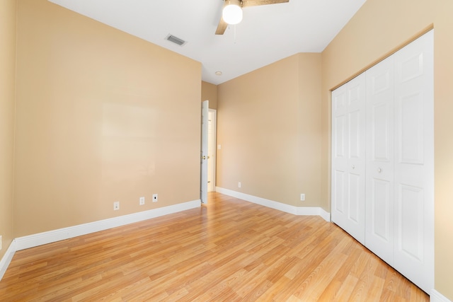 unfurnished bedroom with ceiling fan, light wood-type flooring, and a closet