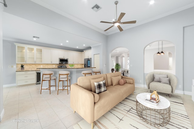 tiled living room featuring ornamental molding, wine cooler, and ceiling fan