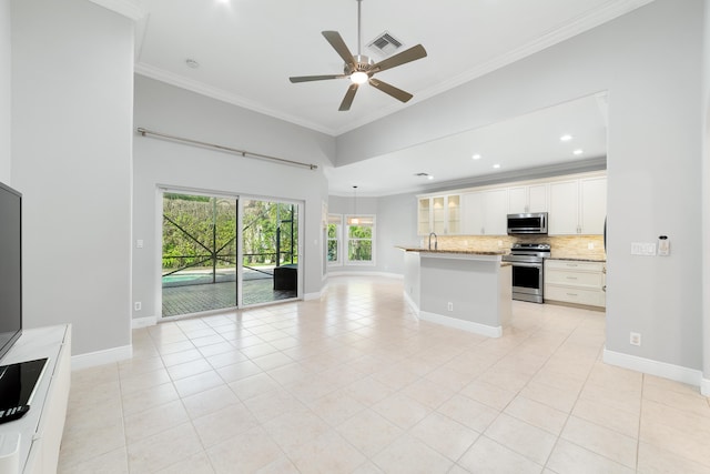 kitchen with light tile patterned floors, stainless steel appliances, ornamental molding, white cabinets, and decorative backsplash