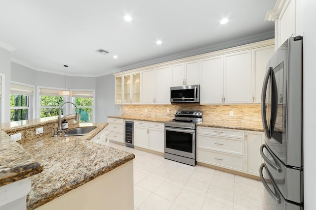 kitchen featuring sink, crown molding, decorative light fixtures, appliances with stainless steel finishes, and beverage cooler