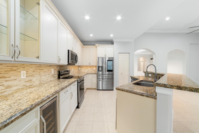 kitchen featuring sink, crown molding, appliances with stainless steel finishes, wine cooler, and stone countertops