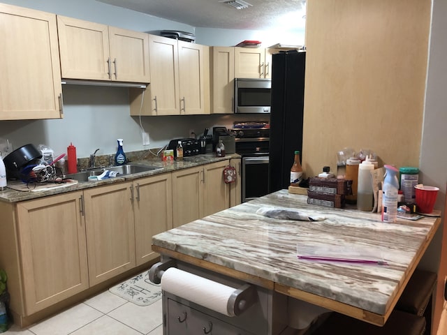 kitchen featuring light brown cabinetry, sink, and appliances with stainless steel finishes