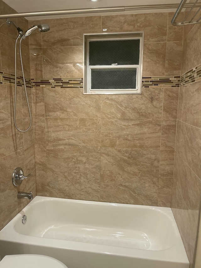 bathroom with tiled shower / bath and toilet