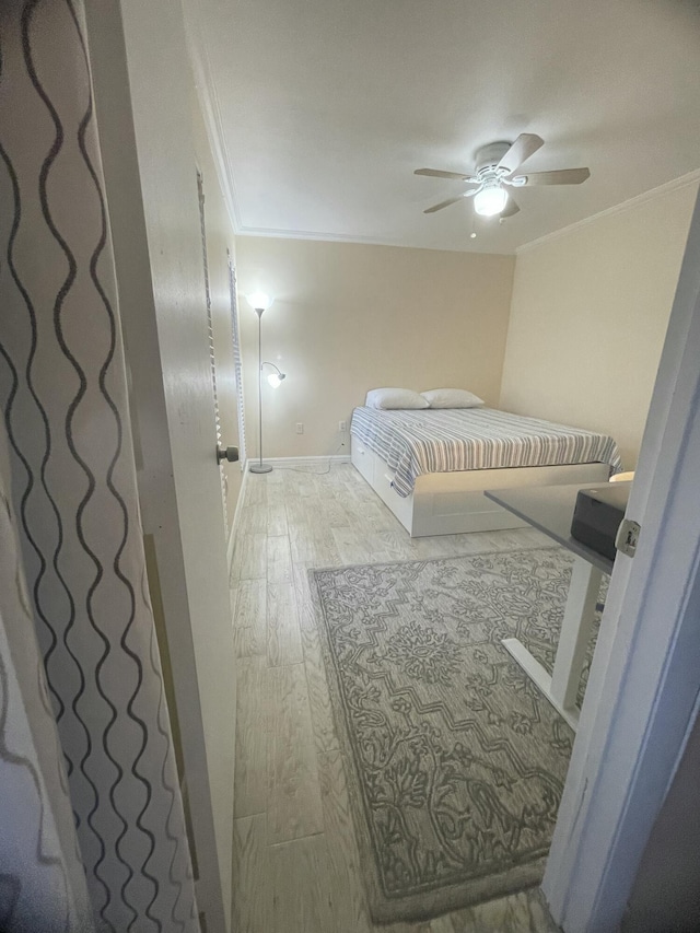 bedroom featuring ornamental molding, ceiling fan, and light wood-type flooring