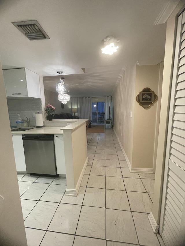 kitchen featuring pendant lighting, sink, light tile patterned floors, white cabinetry, and stainless steel dishwasher