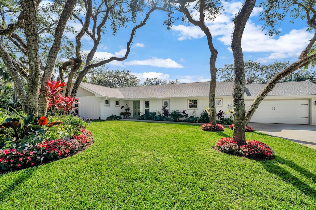 single story home with a garage and a front yard