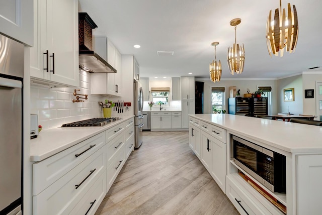 kitchen with stainless steel appliances, light countertops, white cabinetry, and decorative backsplash