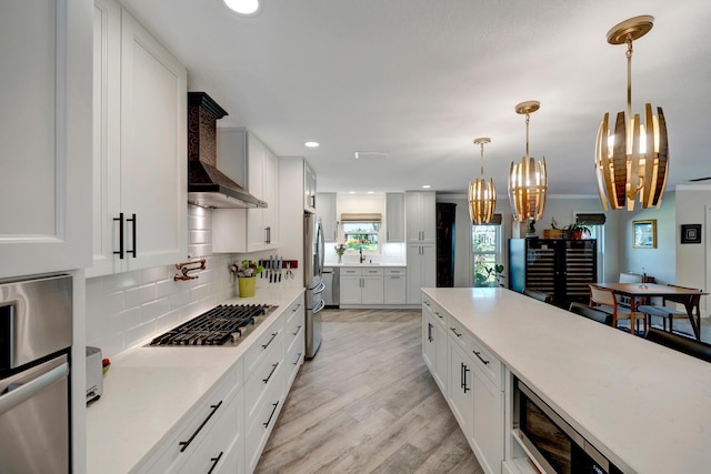 kitchen featuring stainless steel appliances, white cabinets, and light countertops