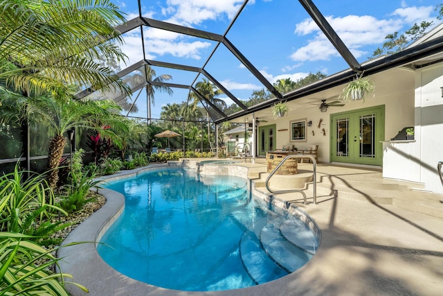 view of swimming pool featuring a patio, a lanai, a pool with connected hot tub, a ceiling fan, and french doors