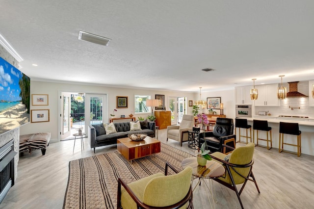 living room featuring plenty of natural light, visible vents, and light wood-style flooring