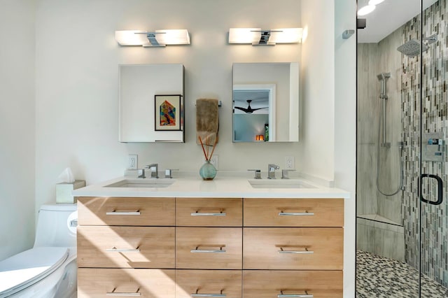 full bathroom featuring a sink, a shower stall, toilet, and double vanity