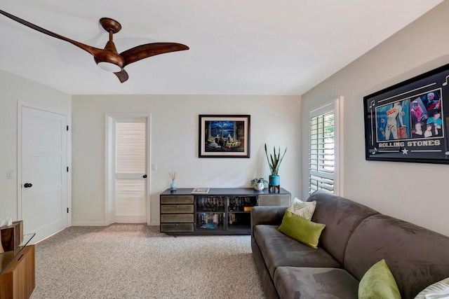 living room with light colored carpet, ceiling fan, and baseboards