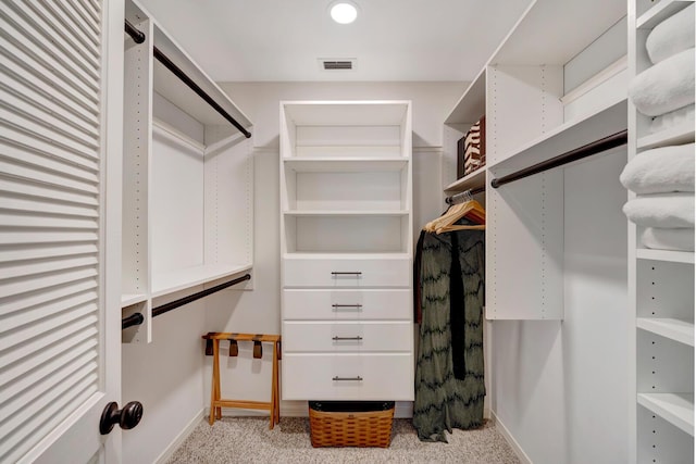 walk in closet featuring visible vents and light colored carpet