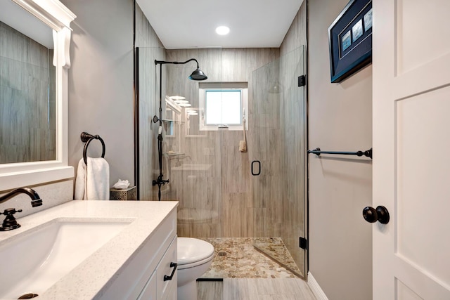 full bath with a stall shower, vanity, and toilet