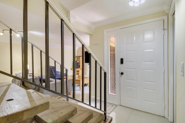 entrance foyer featuring crown molding and light tile patterned floors