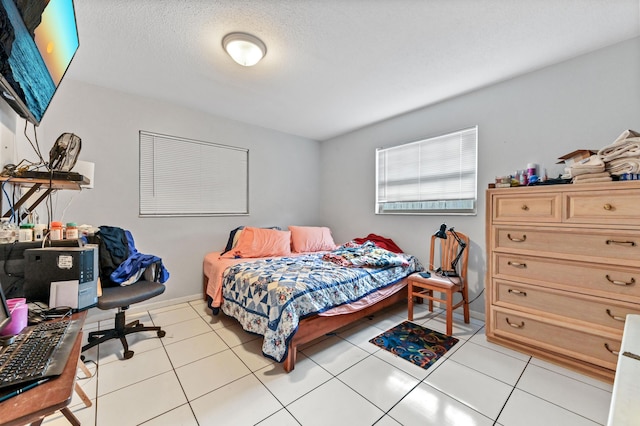 bedroom featuring light tile patterned floors and a textured ceiling