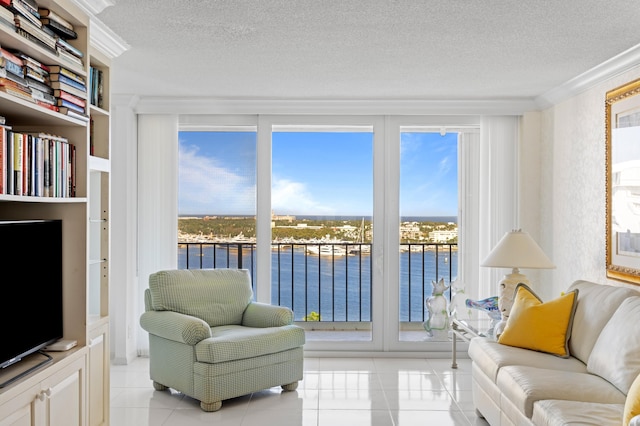 living room featuring a water view, crown molding, a textured ceiling, and light tile patterned floors