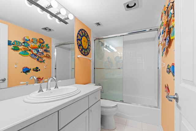 full bathroom featuring tile patterned flooring, bath / shower combo with glass door, vanity, and toilet