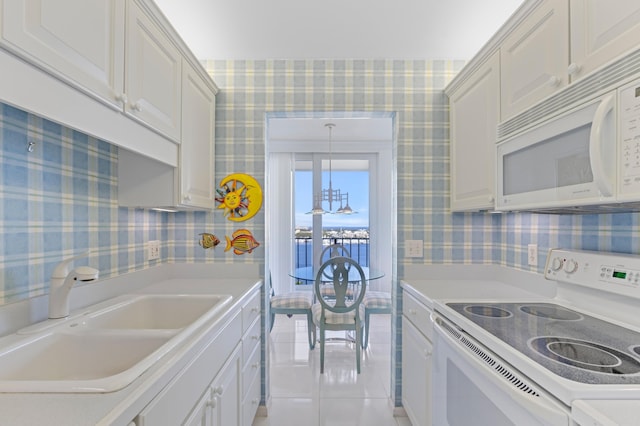 kitchen featuring sink, white appliances, light tile patterned flooring, decorative light fixtures, and a chandelier