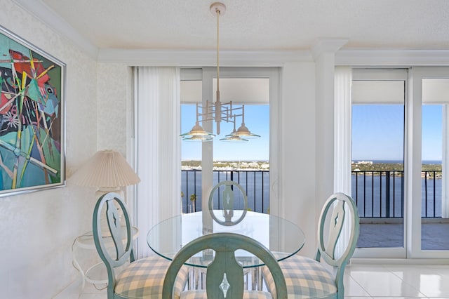 dining room with a water view, light tile patterned floors, and a textured ceiling