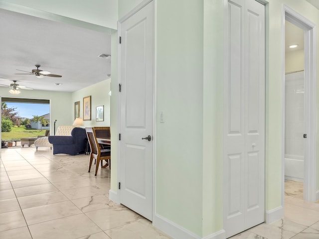 hallway with visible vents, marble finish floor, and baseboards