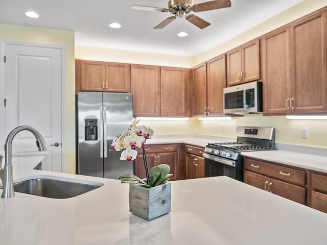 kitchen featuring a sink, brown cabinets, appliances with stainless steel finishes, and light countertops