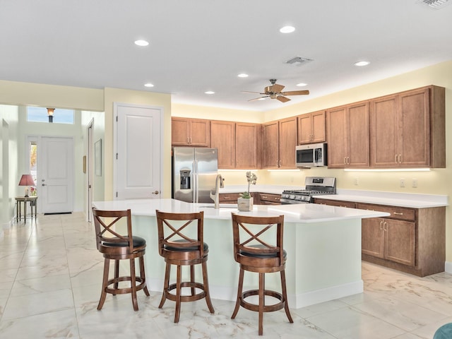 kitchen with visible vents, marble finish floor, appliances with stainless steel finishes, and brown cabinetry