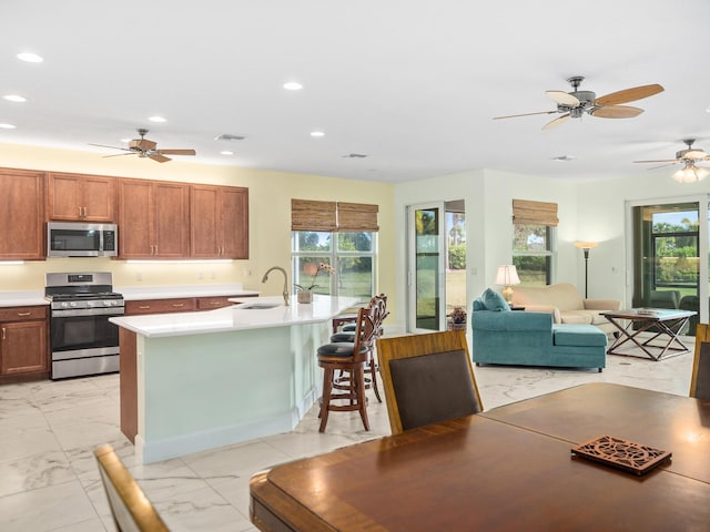 kitchen featuring a sink, marble finish floor, appliances with stainless steel finishes, and light countertops