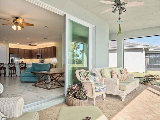 sunroom / solarium featuring visible vents and a ceiling fan